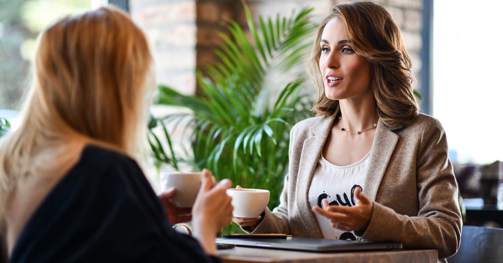 Two women chat together in a foreign language