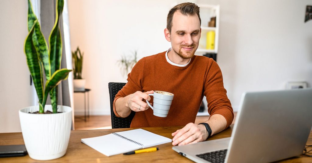 Man learning a language from home with a cup of coffee