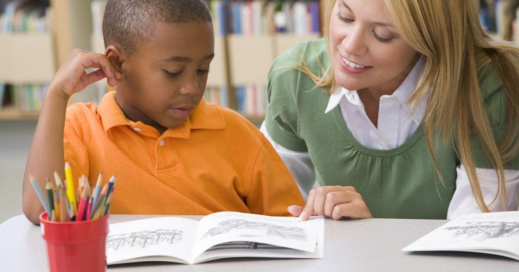 Child reading a book to learn a language