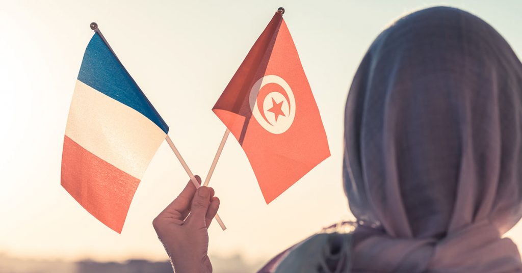 Woman holding the French and Tunisian flags